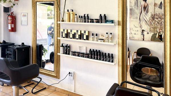 salon de belleza con estaterías con productos y sillas